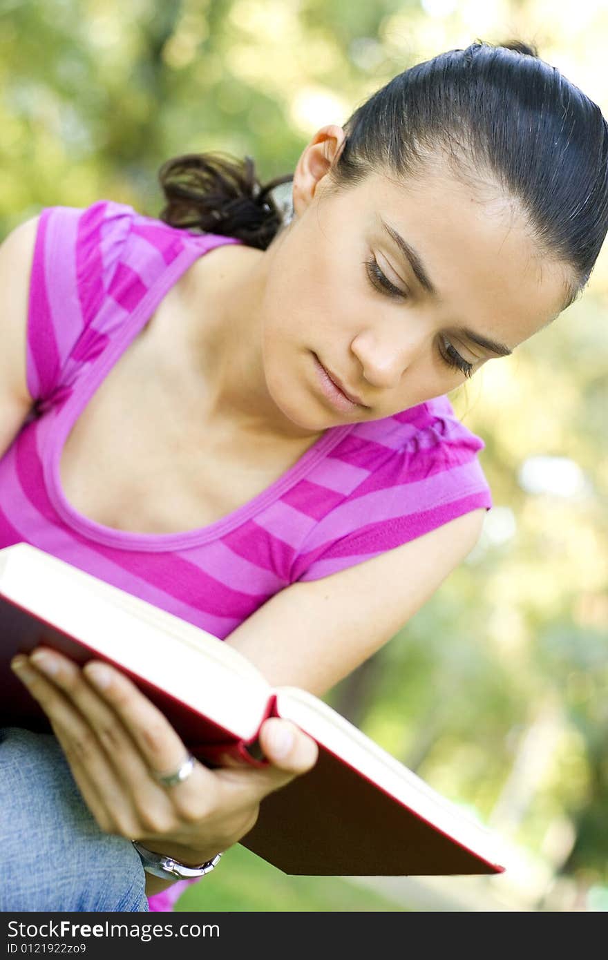 Young woman reading book outdoor. Young woman reading book outdoor