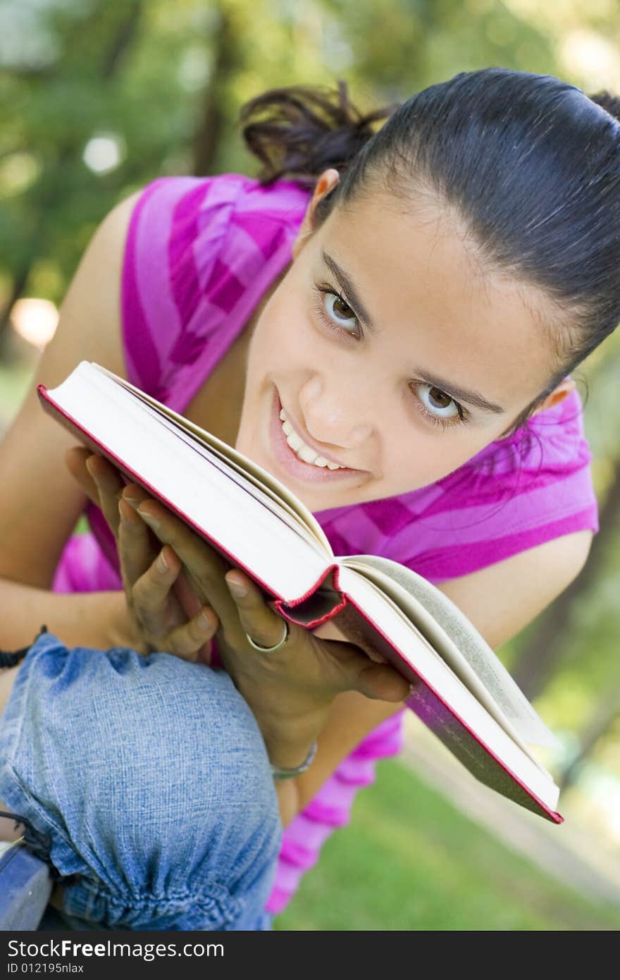 Young woman reading book outdoor. Young woman reading book outdoor