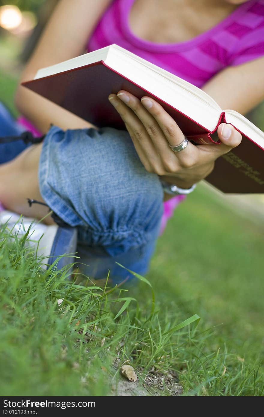 Young woman reading book outdoor. Young woman reading book outdoor