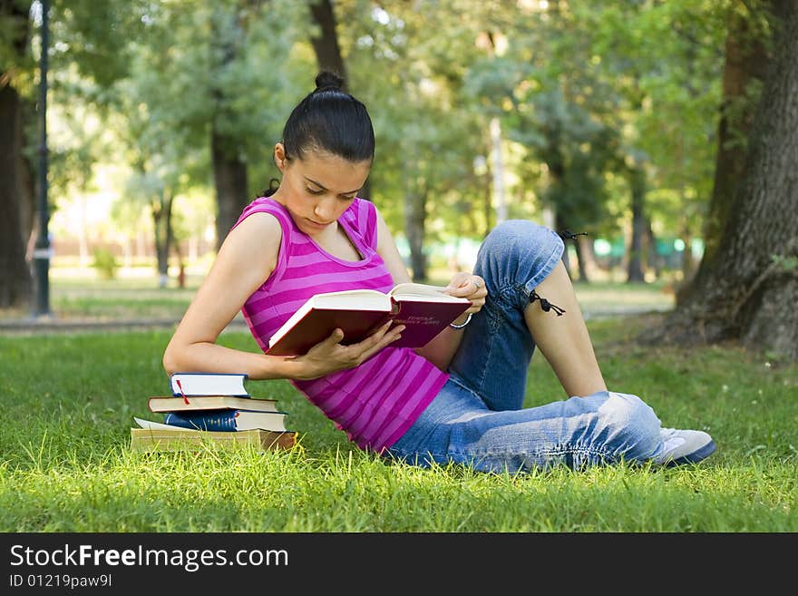 Young woman reading book outdoor. Young woman reading book outdoor