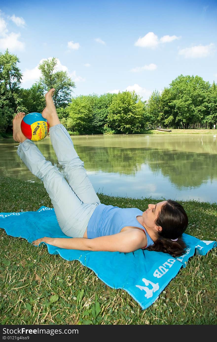 Girl Exercising Outdoors With Ball Near Lake