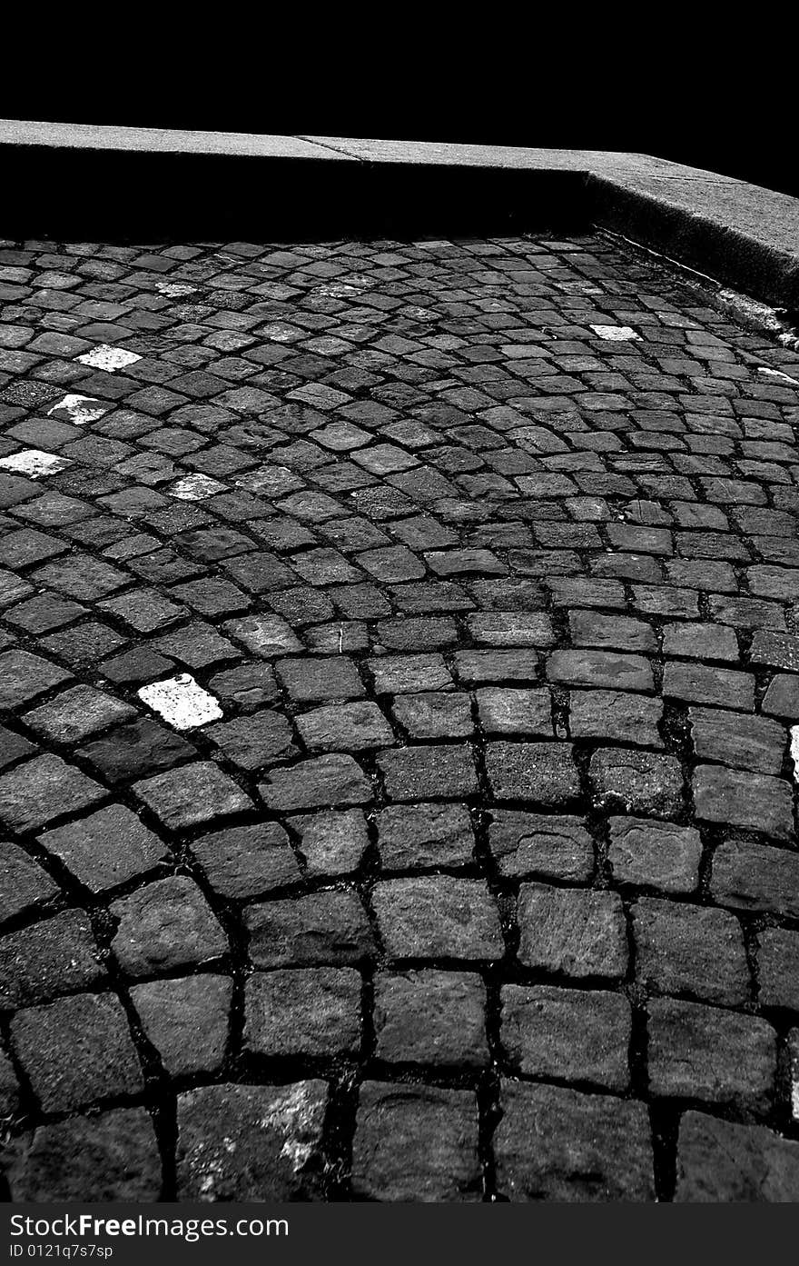 High contrast grayscale picture of an old stone pavement and a stone curb. High contrast grayscale picture of an old stone pavement and a stone curb