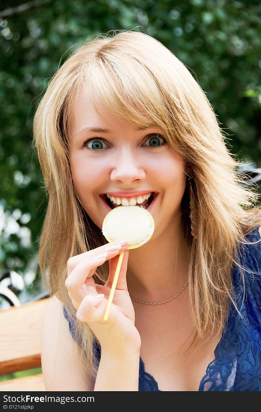 Pretty playful girl eating a candy