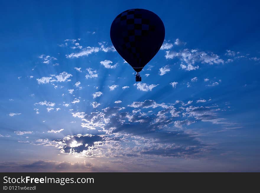 A hot air balloon is silhouetted at sunset. A hot air balloon is silhouetted at sunset.