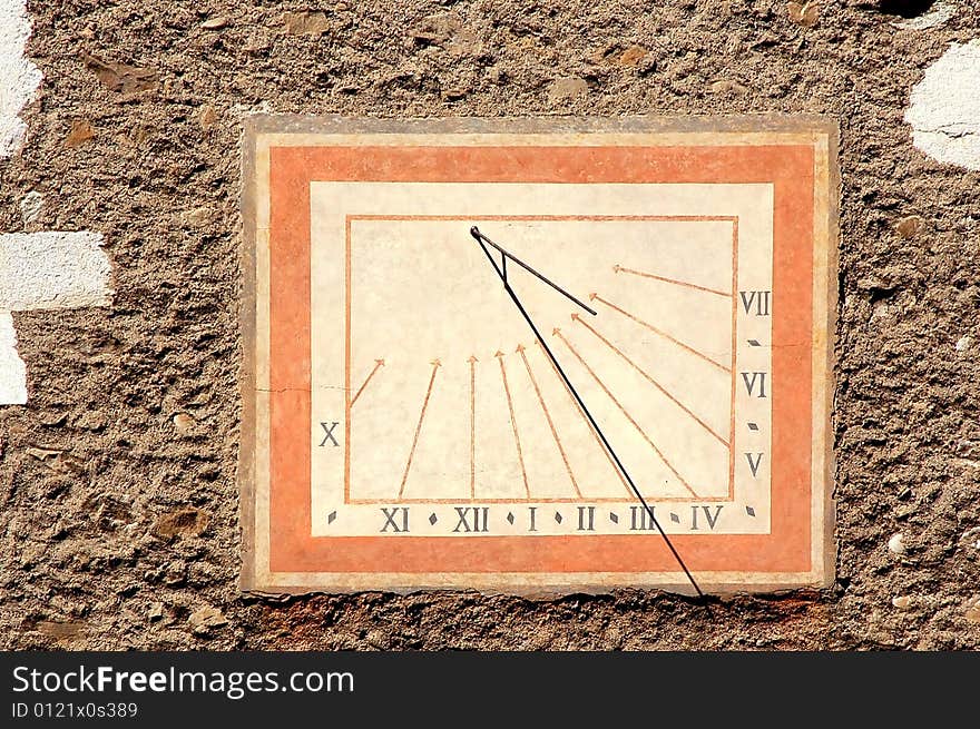 Medieval sundial with roman numerals on an old stone wall. Medieval sundial with roman numerals on an old stone wall