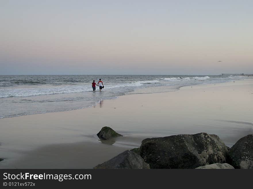 Couple holding hands while walking on beach. Couple holding hands while walking on beach