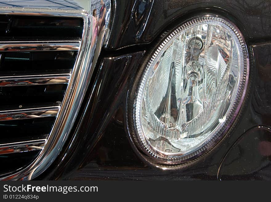 Detail of new modern black car - head lamp and radiator. Detail of new modern black car - head lamp and radiator