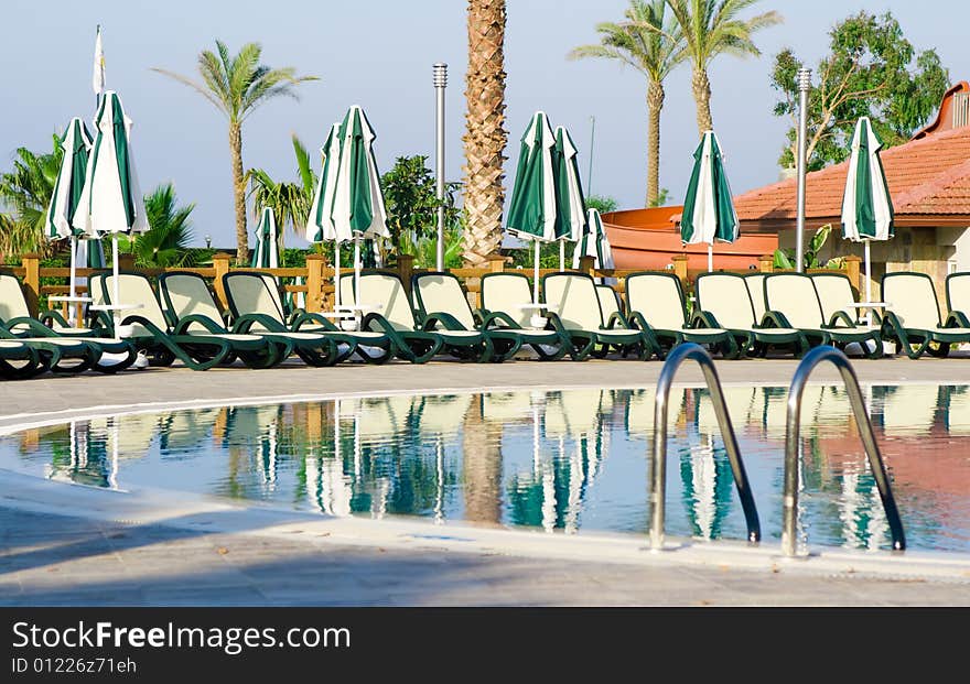 Chaise longues near pool full with water