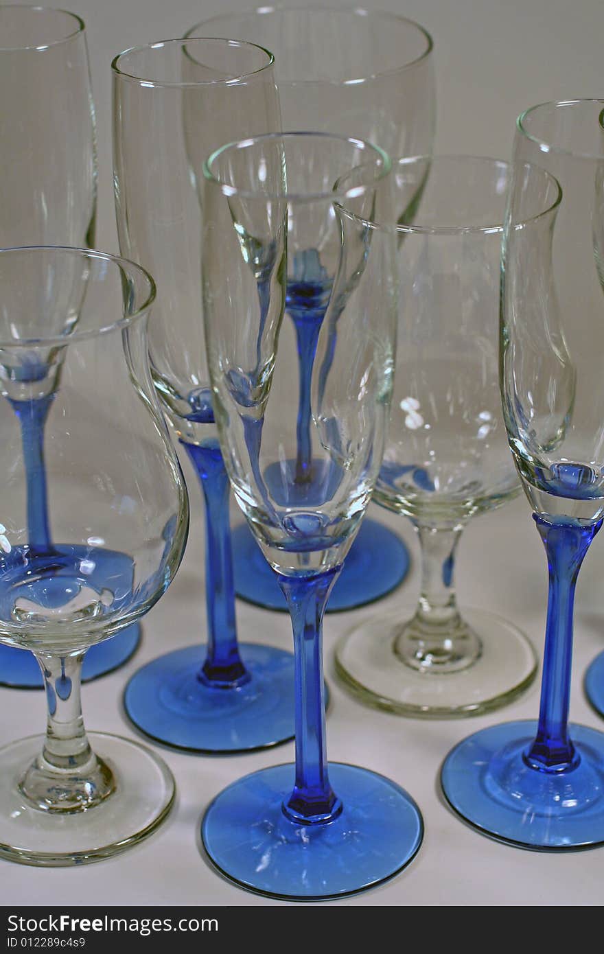 Several clean and shiny wine glasses with blue stems isolated and ready for a party!. Several clean and shiny wine glasses with blue stems isolated and ready for a party!