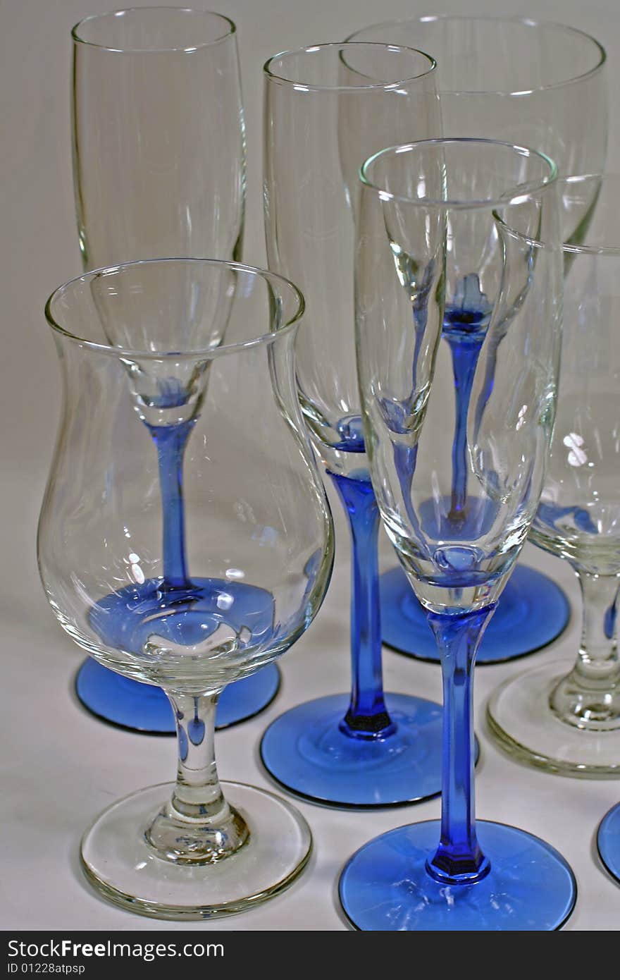 Several clean and shiny wine glasses with blue stems isolated and ready for a party!. Several clean and shiny wine glasses with blue stems isolated and ready for a party!