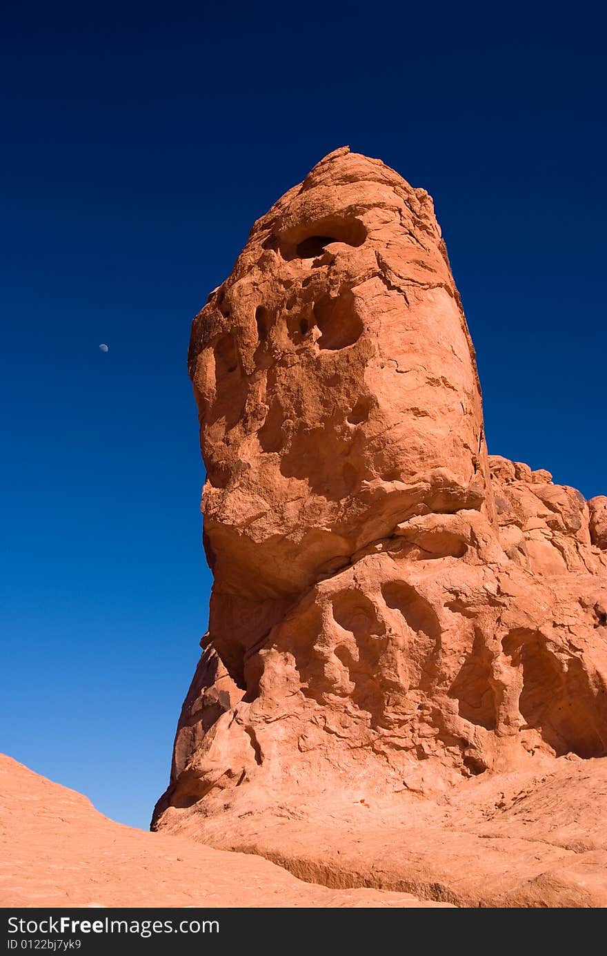 Red Rock With Moon Under Blue Sky