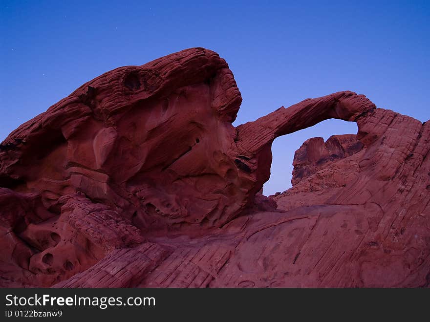 Red rock arch under blue sky