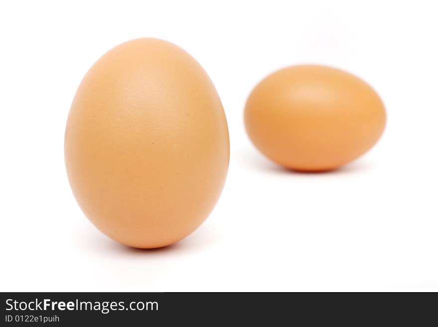 Close up of an egg standing far from the other on white background. Close up of an egg standing far from the other on white background.