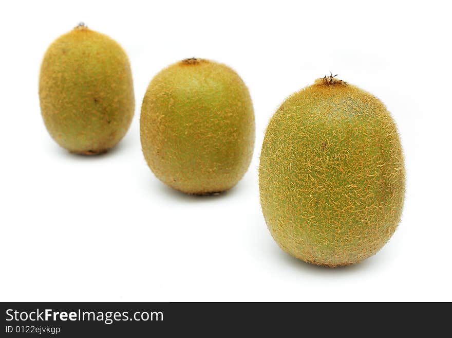 Close up of three kiwi fruits standing on white background.