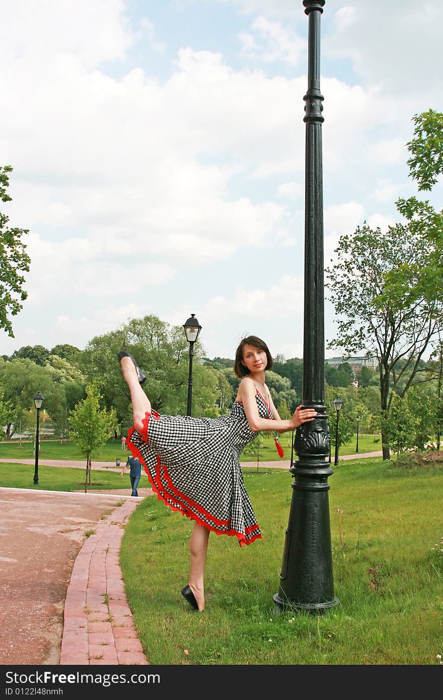 The beautiful girl poses at a lamppost. The beautiful girl poses at a lamppost