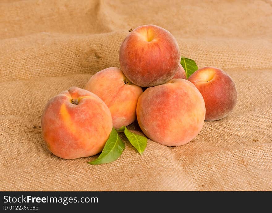 Ripe peaches on burlap texture