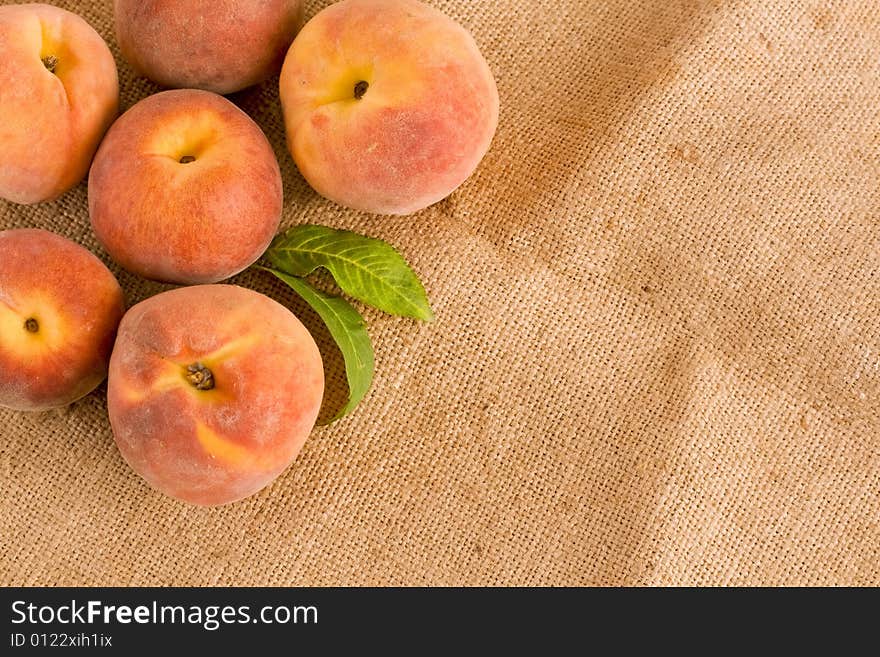 Ripe peaches on burlap texture