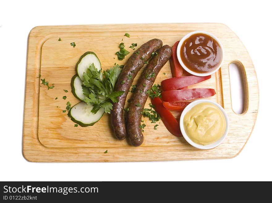 Two long frankfurters with pepper, cucumber, herbs and two kinds of sauces - mustard and ketchup on wooden board