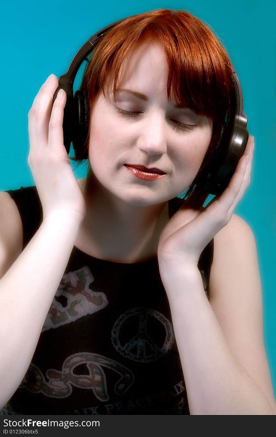 Red haired girl listening to her favourite music. Red haired girl listening to her favourite music