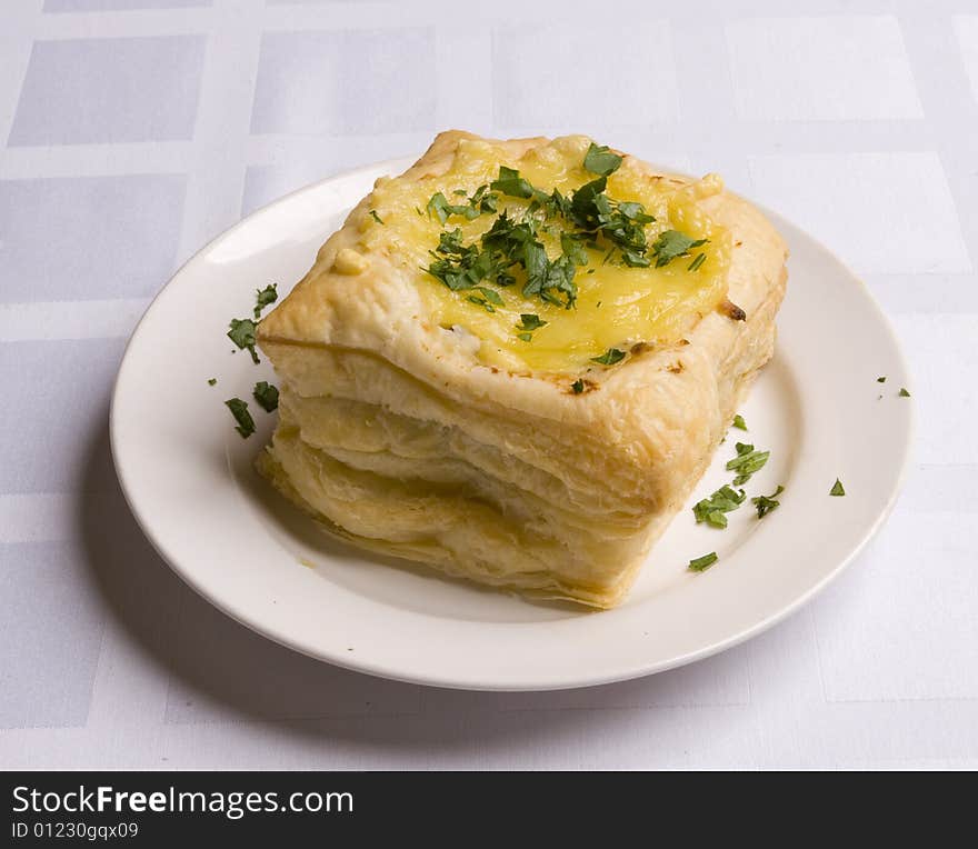 Pie with cheese on white plate