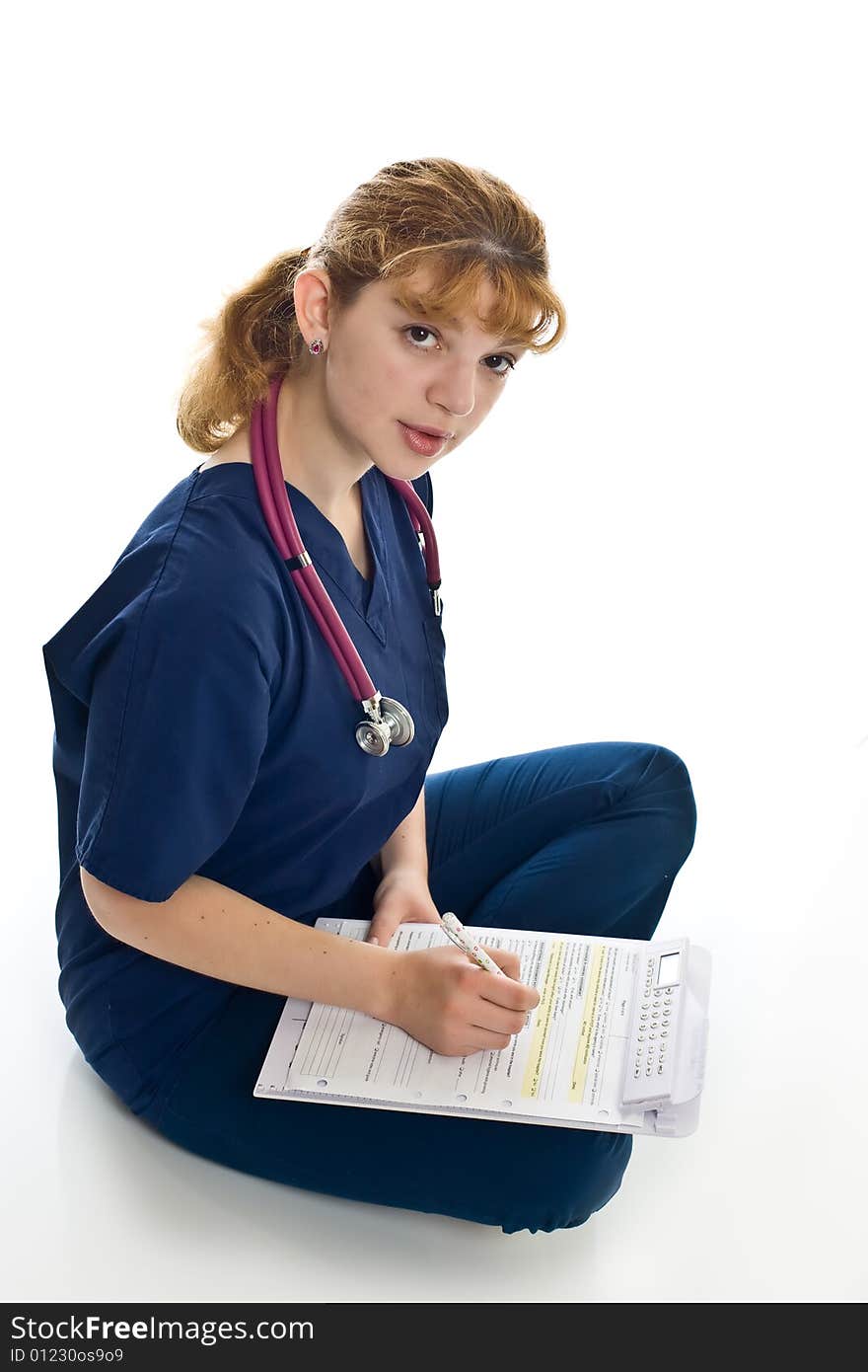 Young female doctor with stethoscope and writing pad over white background