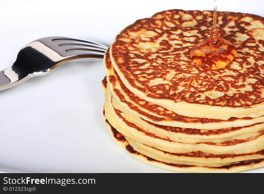 Pile of american pancakes with syrup poured on them. Pile of american pancakes with syrup poured on them