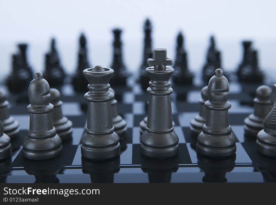 Metal Chess pieces facing eachother with white background. Metal Chess pieces facing eachother with white background