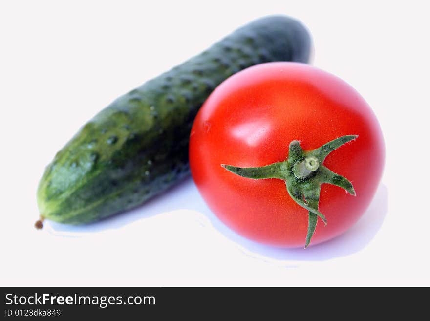 A fresh tomato and cucmber isolated on white background. A fresh tomato and cucmber isolated on white background