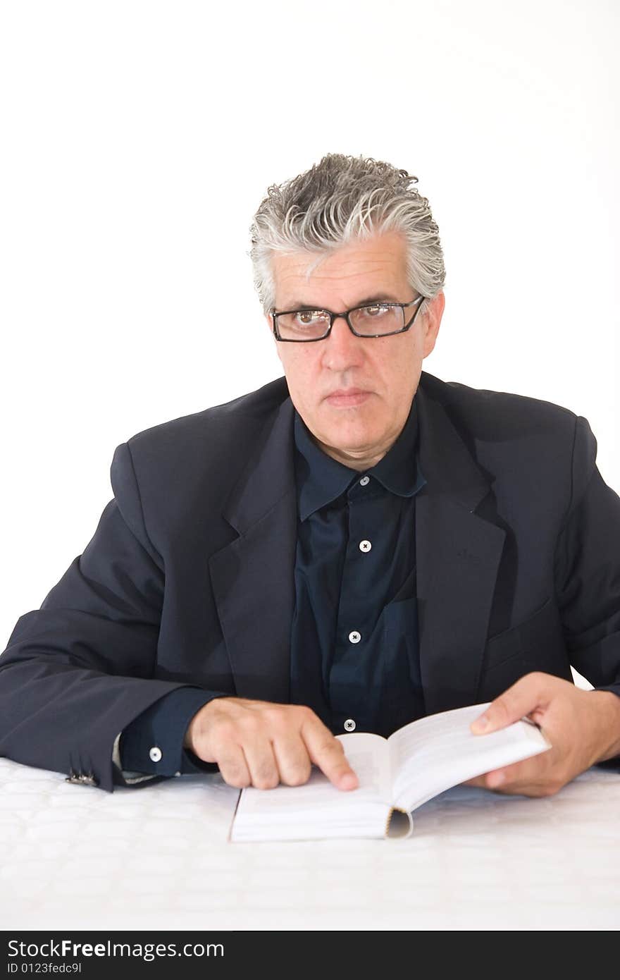 A  businessman reading a bookat work in his office in moment of the day. A  businessman reading a bookat work in his office in moment of the day.