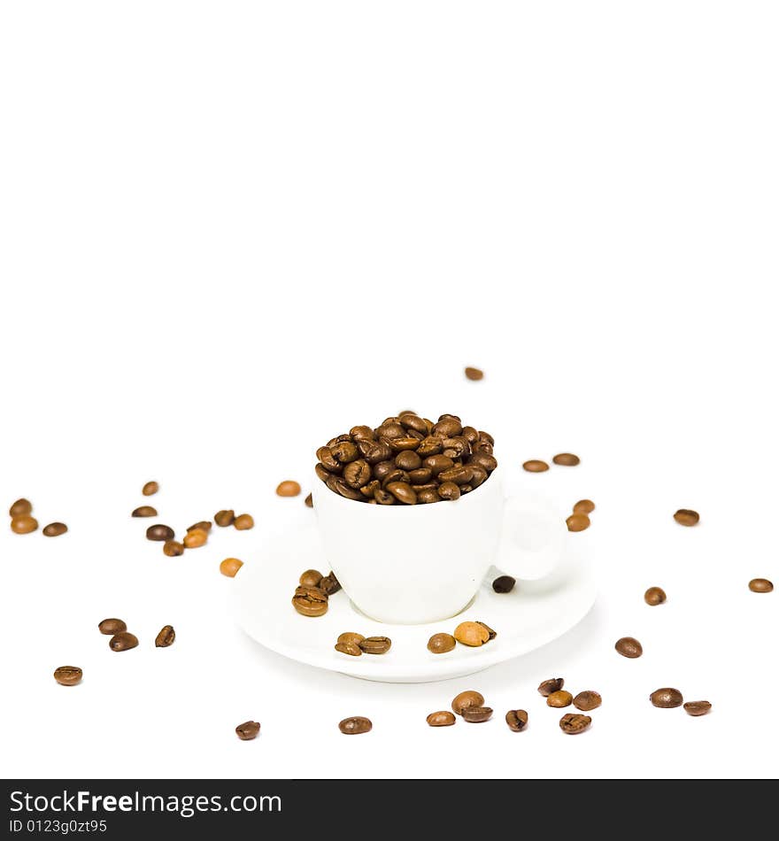 A white cup with coffee beans on white background