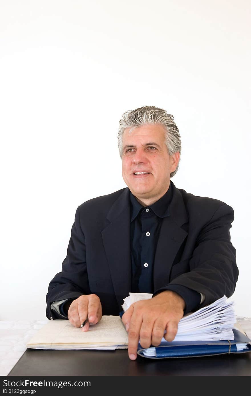 A businessman at work in his office writing a report