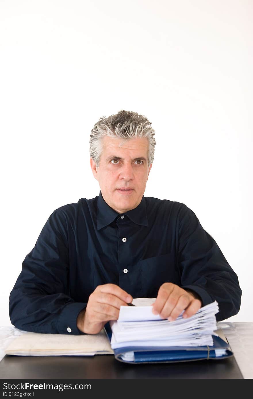 A businessman at work in his office checking papers