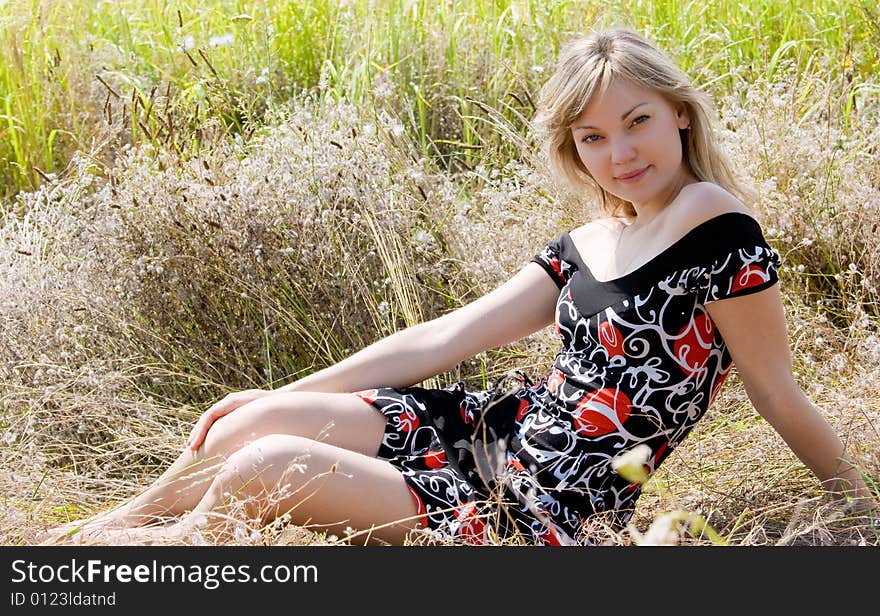 Beautiful young girl on summer meadow background