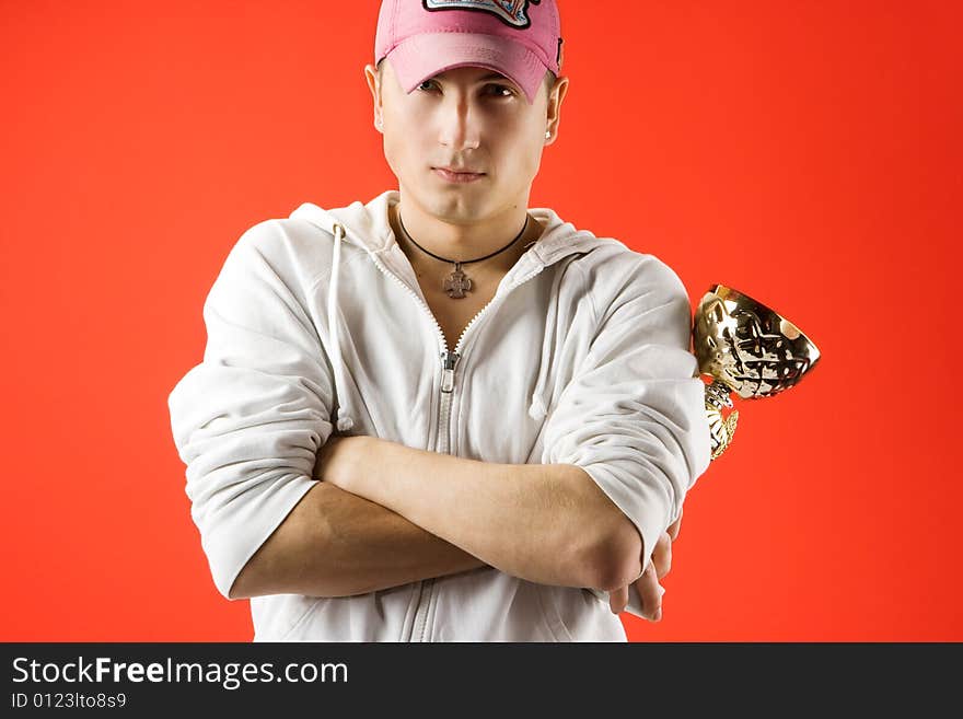 Man with golden trophy on red background