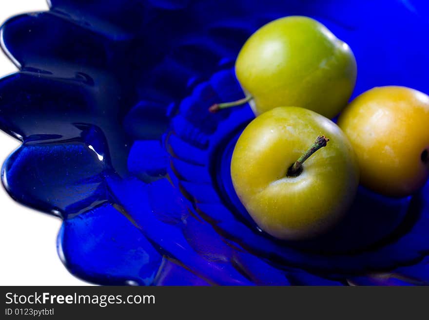 Group of plums on blue glass plate. Group of plums on blue glass plate