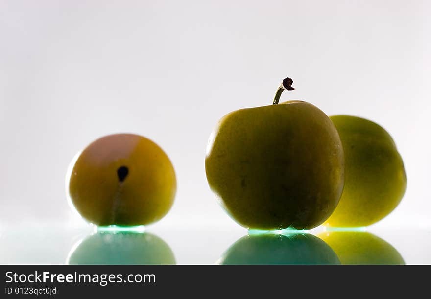 Three plums with reflection