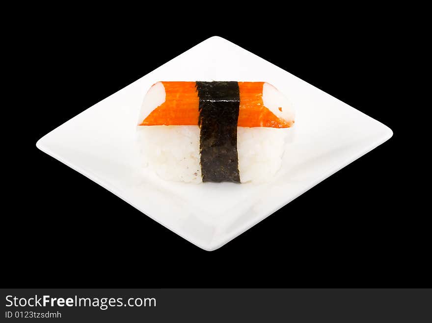 A square white plate with a piece of sushi