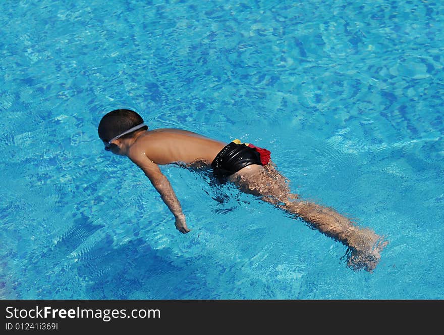 The boy swim in the blue water