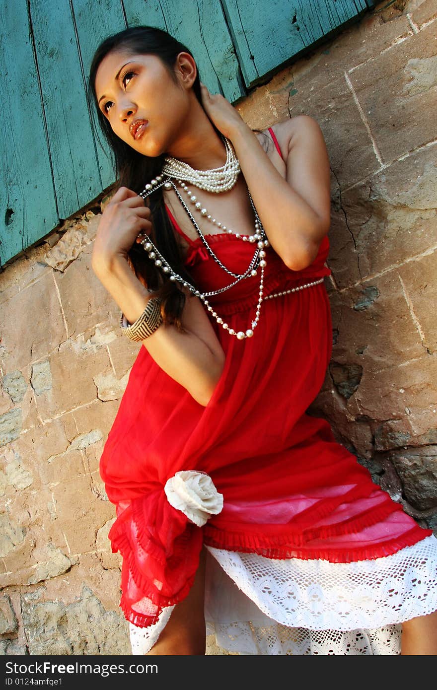 Fashion photo of filipino woman against barn wall