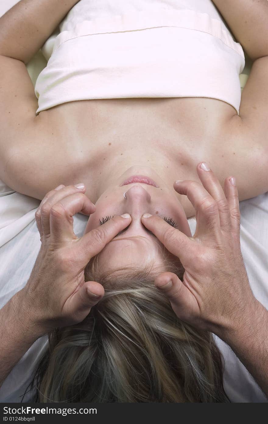 Woman getting facial massage from a masseur. Woman getting facial massage from a masseur