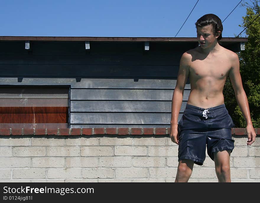 Teenager standing on the edge of a pool. Teenager standing on the edge of a pool.