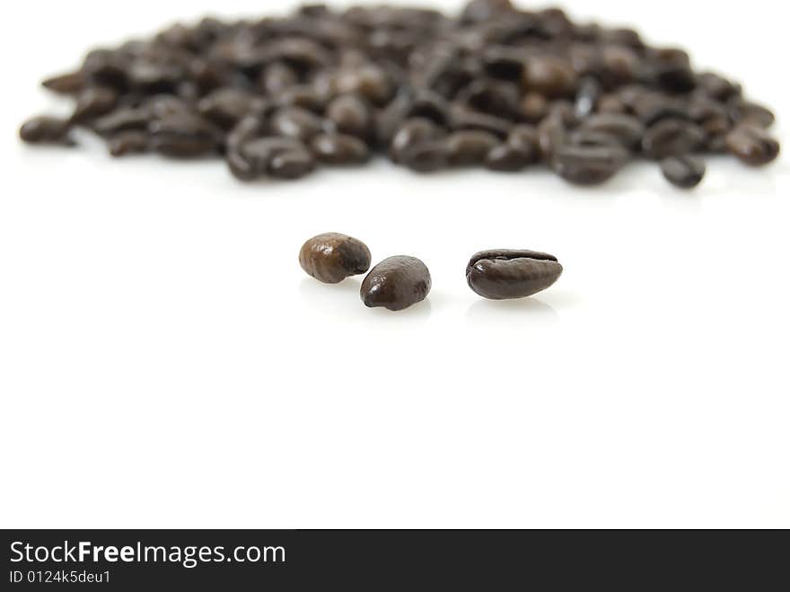 Closeup shot of coffee beans against white background with Tarragon herb on top