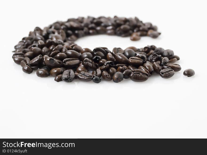 Closeup shot of coffee beans against white background with Tarragon herb on top