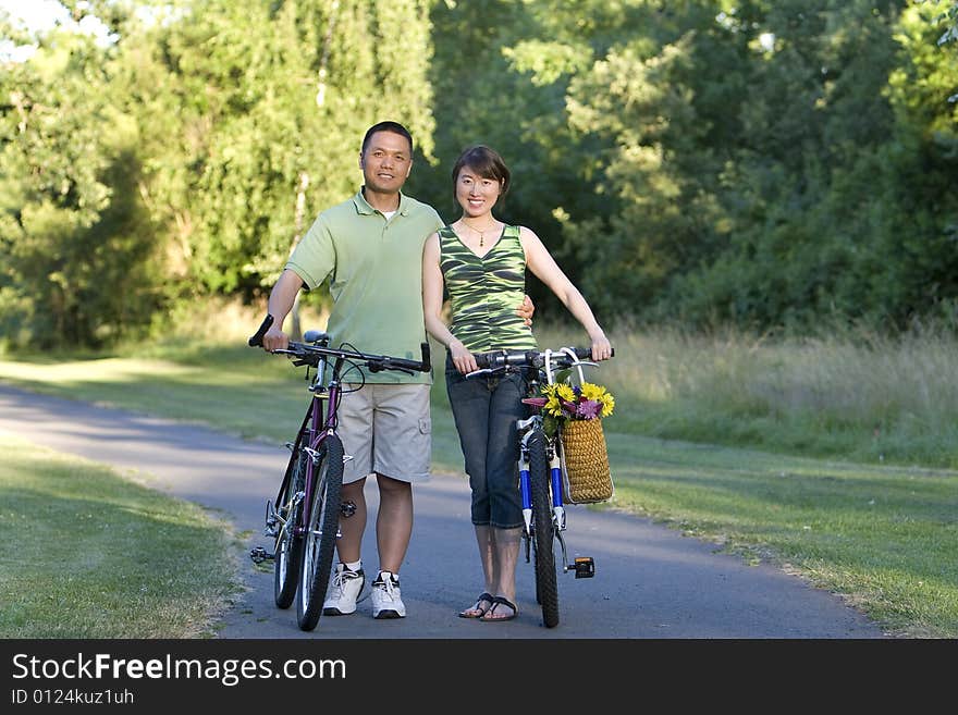 Couple Stands With Bicycles Smiling - Horizontcal