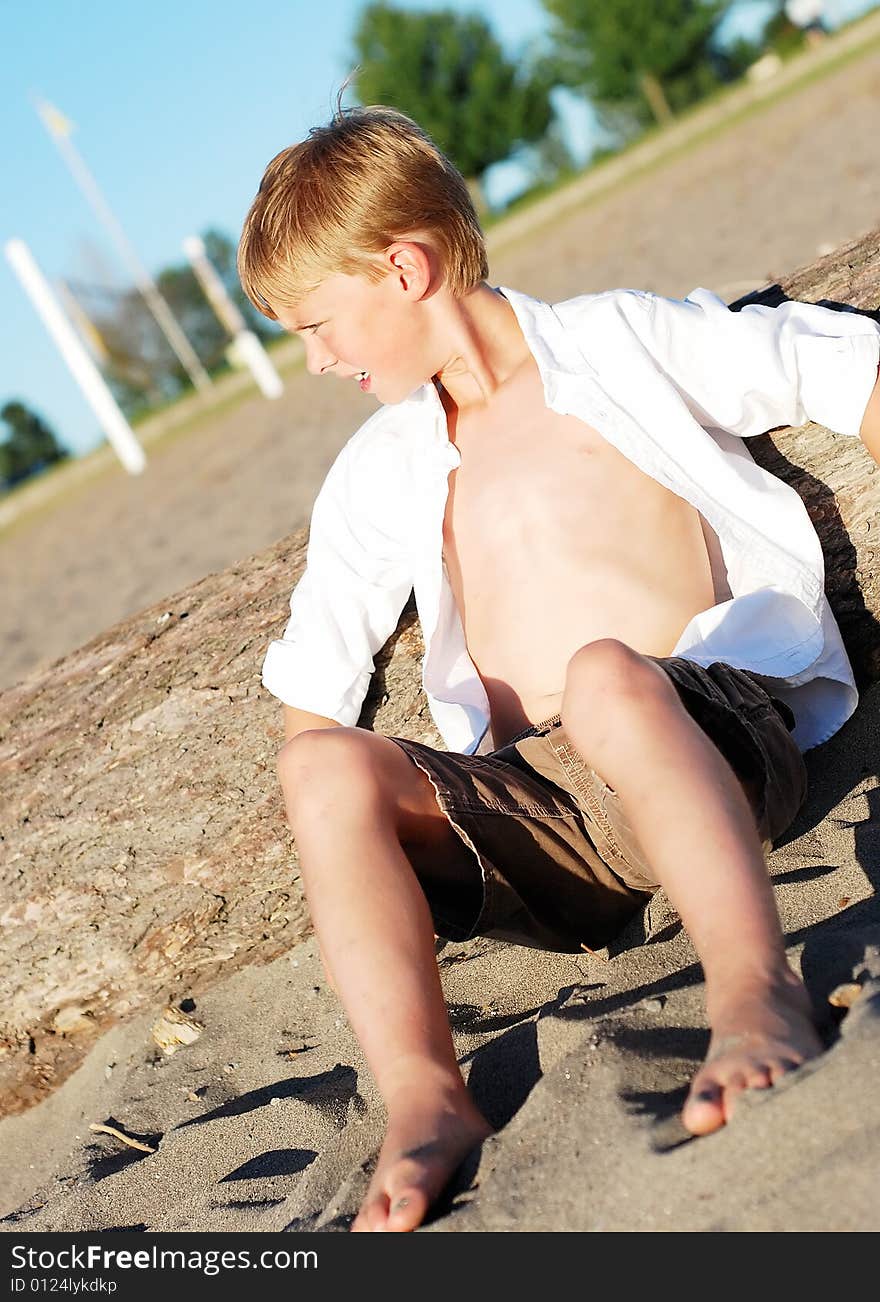 Boy Sitting in Sand on Beach - Vertical