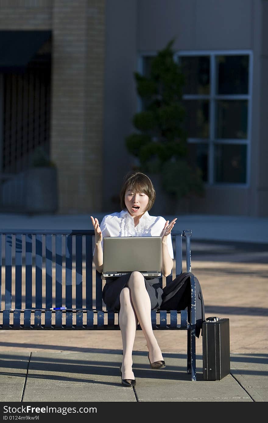 Woman Sits on a Bench with her Laptop - Vertictal