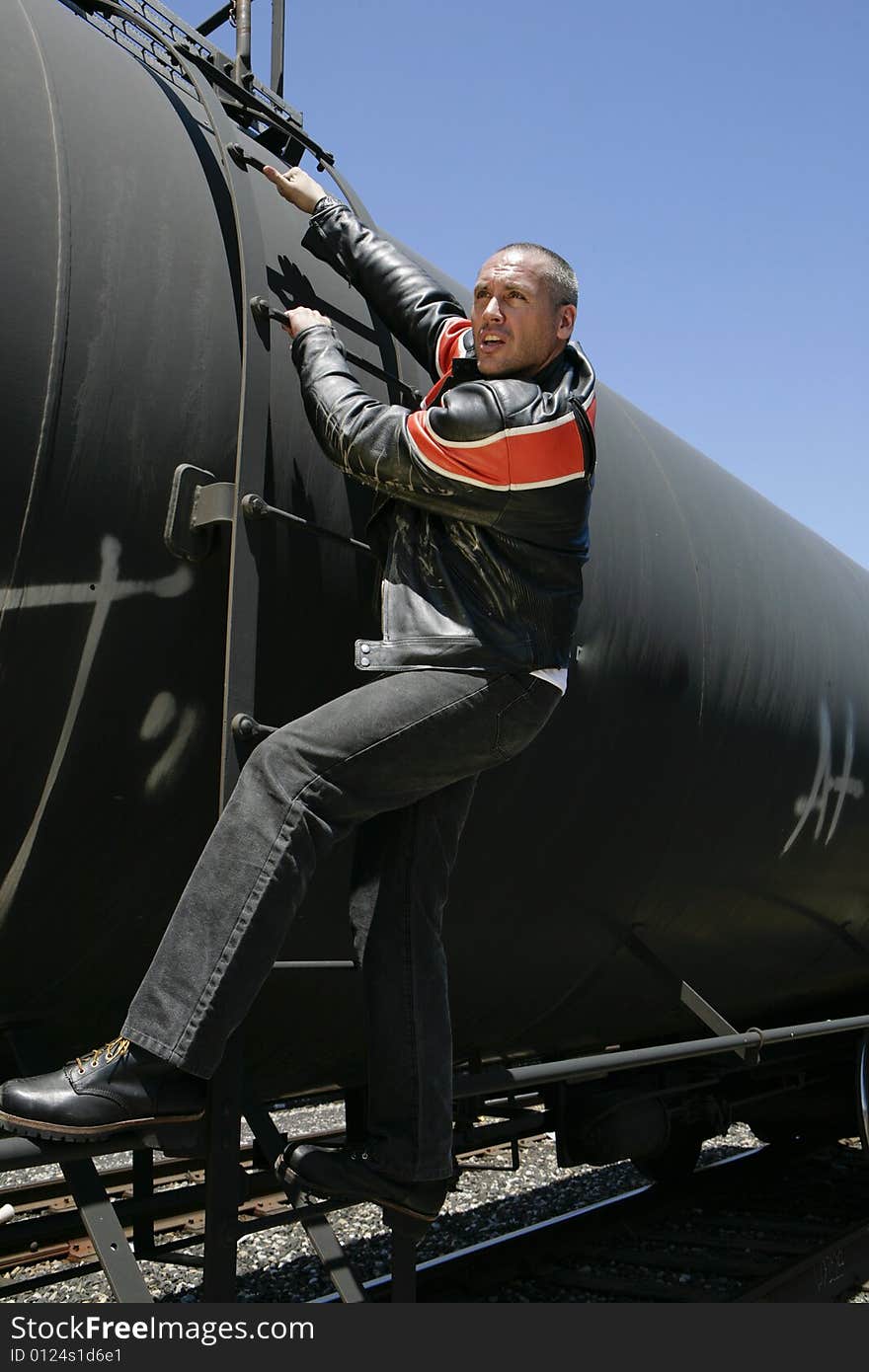 Male fashion model posing outdoors on a train. Male fashion model posing outdoors on a train