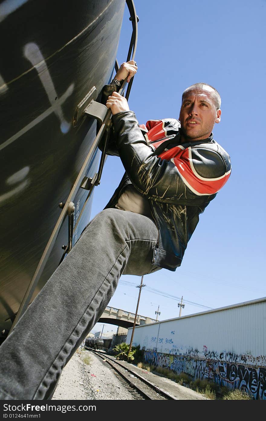 Male fashion model posing outdoors on a train. Male fashion model posing outdoors on a train