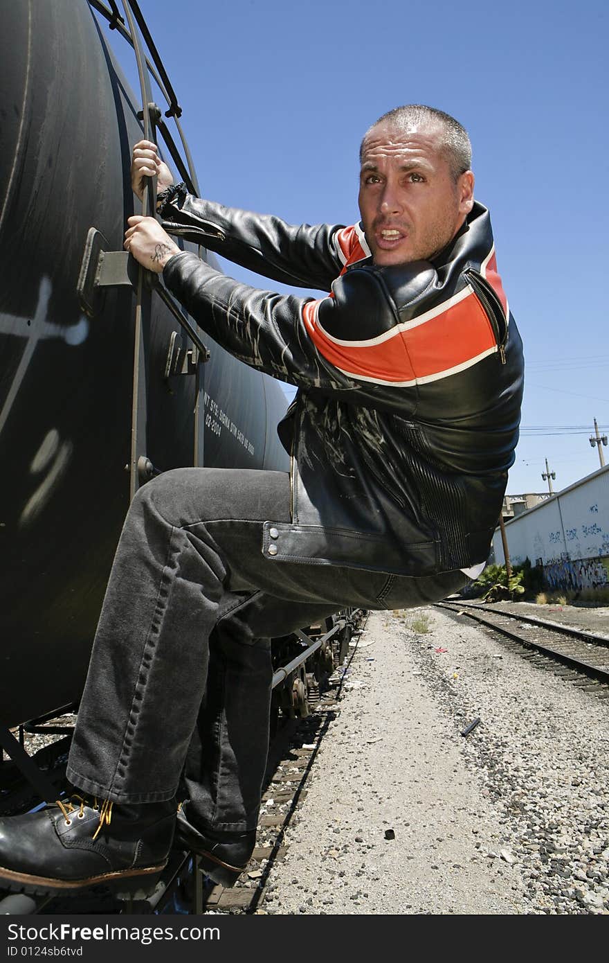 Male fashion model posing outdoors on a train. Male fashion model posing outdoors on a train