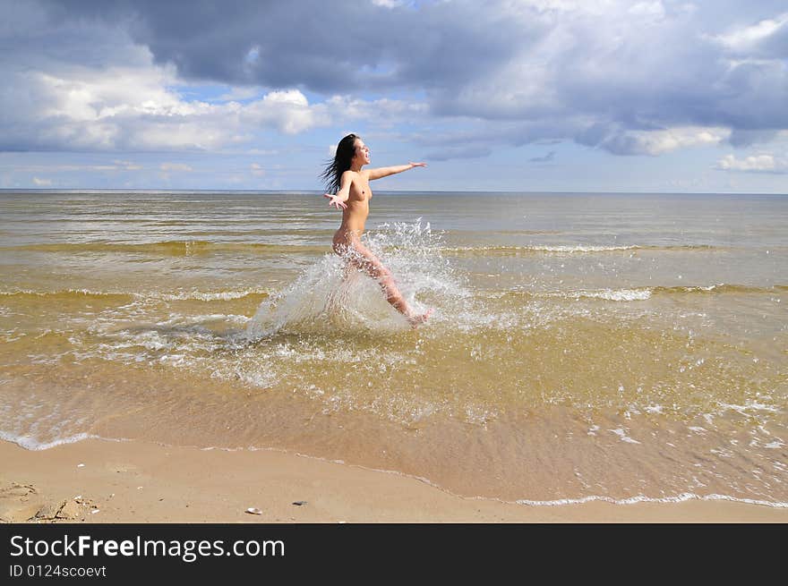 Naked girl running on the beach